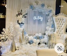 a white and blue christmas themed wedding set up with balloons, snowflakes, and decorations