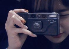 a woman holding up a camera to take a selfie with her face close to the camera