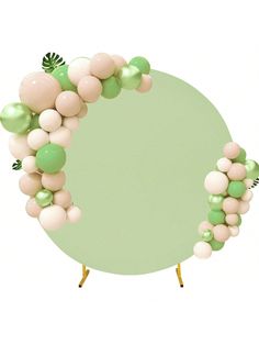 a green and white balloon arch on top of a round table