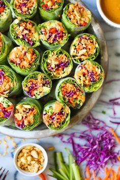 a platter filled with lots of veggies next to some dipping sauces