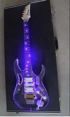 an electric guitar with purple lights on it