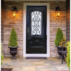 a black front door with two planters on either side and one light above it