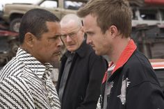 three men standing next to each other talking