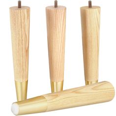 three wooden rollers are lined up in the same row and one is gold colored