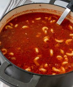 a pot filled with pasta and sauce on top of a stove