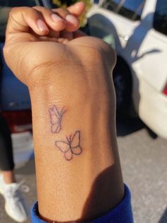 a woman's arm with a tattoo on it that has two butterflies on it