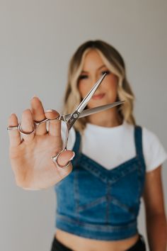 a woman holding scissors in her right hand