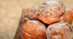 powdered sugar covered donuts on a brown plate