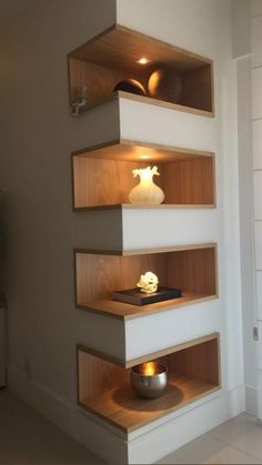 three wooden shelves in the corner of a room with light coming from above and below