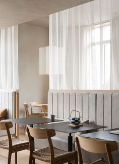 a table and chairs in a room with sheer curtains