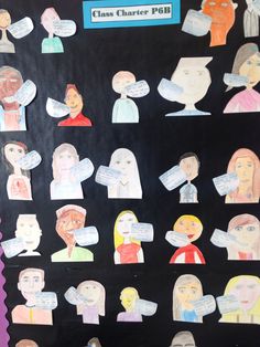 a bulletin board with paper cutouts of people and words written on the back wall