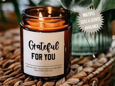 a candle that is sitting on some kind of table cloth with the words grateful for you printed on it