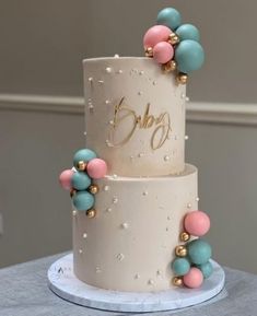 a three tiered wedding cake decorated with pastel colors and gold beads on top