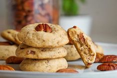 several cookies stacked on top of each other with pecans scattered around them and one cookie in the middle