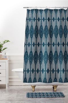 a bathroom with a blue shower curtain and rug in front of the bathtub area