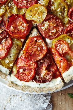 a pizza topped with tomatoes and cheese on top of a white plate