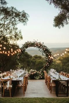 an outdoor dining area with tables and chairs set up for a wedding reception in the woods