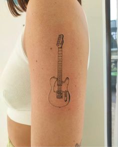 a woman's arm with a guitar tattoo on the left side of her body