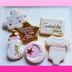 some cookies that are laying on a table with pink and gold trimmings around them