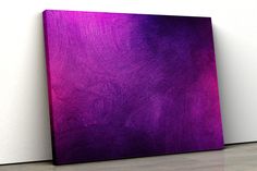 a purple painting sitting on top of a white wall