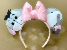 a mouse ears headband with a pink bow