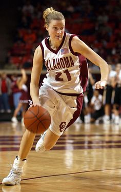 a female basketball player dribbling the ball down the court with her right foot