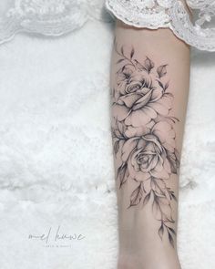 a woman's foot with black and white flowers on the left side of her leg