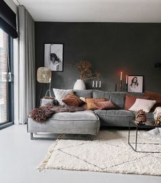 a living room filled with lots of furniture next to a large glass window and a rug on the floor