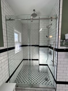 a bathroom with black and white tiles on the floor, shower stall and toilet area