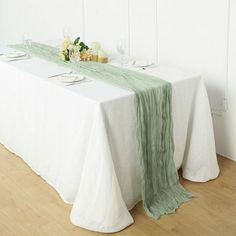 the table is set with white and green linens