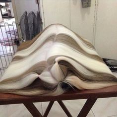 a pile of hair sitting on top of a wooden table next to a wire rack