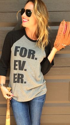 a woman holding a baseball bat and wearing a t - shirt that says for ever