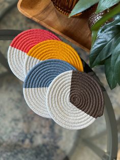 four round coasters sitting on top of a table next to a potted plant