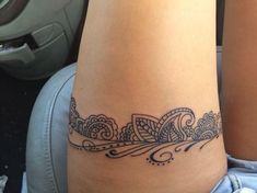 a woman's leg with a tattoo design on the side of her thigh,