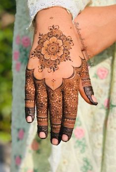 a woman's hand with hennap on it and flowers around the wrist