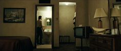 a man standing in the doorway of a hotel room