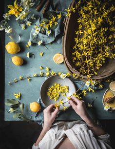 a person sitting on a table with flowers and lemons