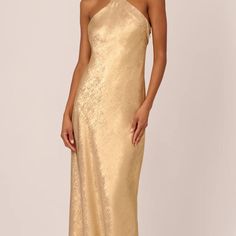 a woman wearing a gold gown with one shoulder and an asymmetrical neckline