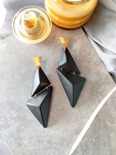 These architectural earrings are inspired by mid-century modern architecture. Their mismatched dangle geometry makes them one-of-a-kind statement earrings. Upcycled Black Leather Earring, Lightweight Mismatched Oversized Earrings. Modern Black Earrings For Party, Unique Black Earrings For Evening, Chic Handmade Black Earrings, Unique Black Geometric Jewelry, Modern Black Geometric Earrings, Modern Black Triangle Jewelry, Architectural Earrings, Architectural Jewelry, Long Earring