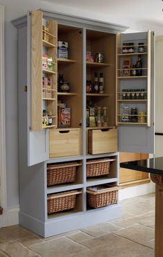 an open cabinet with baskets in it