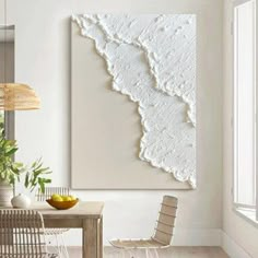 a dining room table with chairs and a painting on the wall