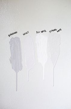 three white spatulas with writing on the wall