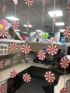 an office cubicle decorated for christmas with candy canes hanging from it's ceiling