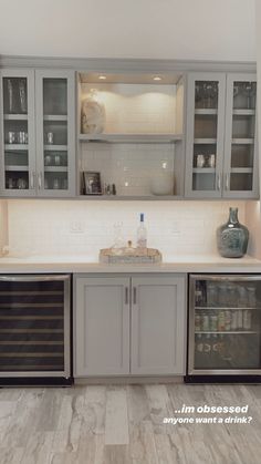 a kitchen with gray cabinets and white counter tops