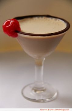 a small glass filled with liquid and topped with a cherry