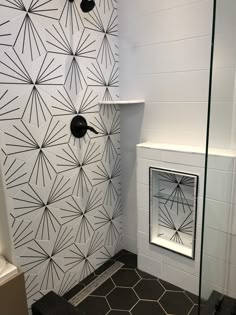 a bathroom with black and white tiles on the walls