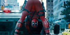 a deadpool character is standing in the street