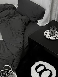 a black and white photo of a bed in a room with pillows on the floor