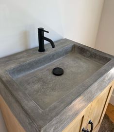 a bathroom sink with a black faucet on the top and a mirror above it