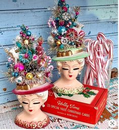 two ceramic heads with christmas decorations and candy canes